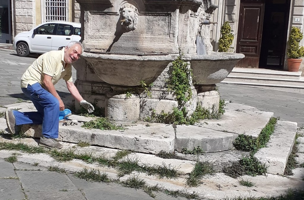 Tre amici per togliere l'erba da piazza del Comune